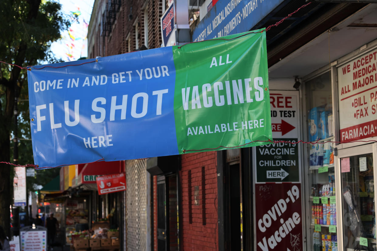 A banner at a pharmacy in New York City reads: Come In and Get Your Flu Shot Here, and All Vaccines Available Here.