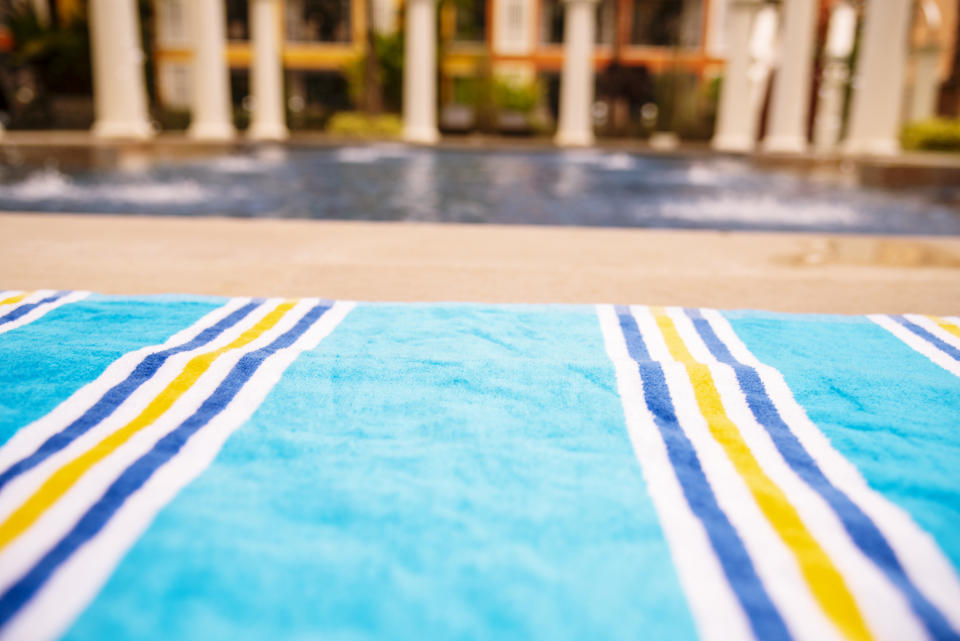 wrinkle beach towel on swimming pool. tropical island summer concept.