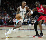 San Antonio Spurs guard Lonnie Walker IV, left, dribbles past Portland Trail Blazers forward Tony Snell during the first half of an NBA basketball game in Portland, Ore., Thursday, Dec. 2, 2021. (AP Photo/Craig Mitchelldyer)