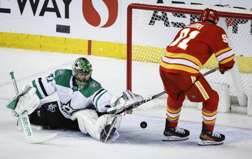 Dallas Stars goalie Scott Wedgewood, left, looks back as Calgary Flames forward Nazem Kadri scores during overtime in an NHL hockey game in Calgary, Alberta, Thursday, Nov. 30, 2023. (Jeff McIntosh/The Canadian Press via AP)