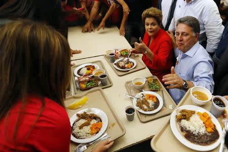 Presidential candidate and Brazilian President Dilma Rousseff (C) of Workers' Party (PT) gestures next to Governor candidate of Rio de janeiro Anthony Garotinho (R) of Party of the Republic (PR) as they visit a popular restaurant during a re-election campaign rally in Rio de Janeiro August 27, 2014. REUTERS/Ricardo Moraes