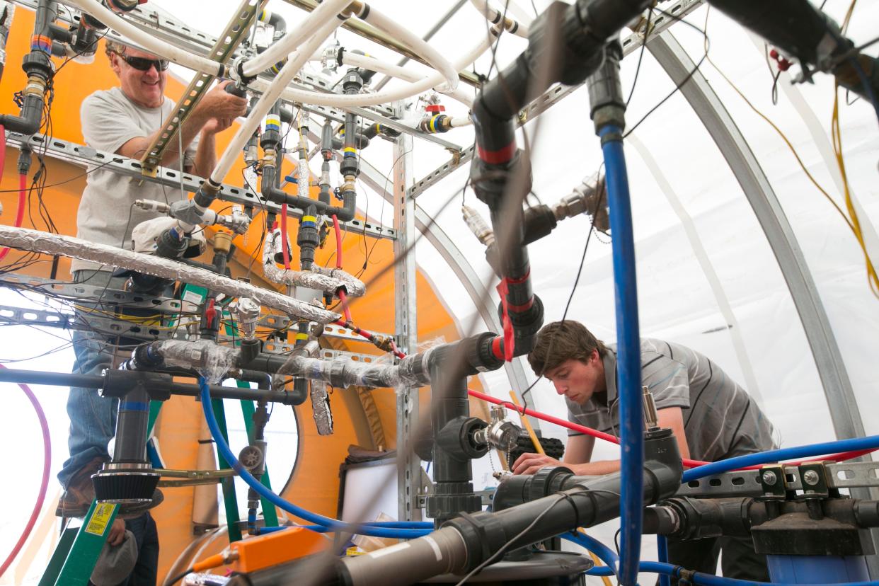 Robert Seaman, left, a University of Arizona chemical and environmental engineering research technician, and Seth Lawrence, a Northern Arizona University mechanical engineering undergrad student, work on repairing a desalinization plant outside of Leupp on the Navajo Reservation on July 22, 2015.