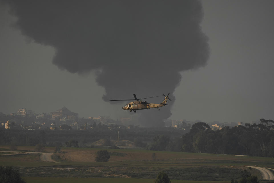 An Israeli military helicopter flies near the Israeli-Gaza border, as seen from southern Israel, Monday, Jan. 1, 2024. The army is battling Palestinian militants across Gaza in the war ignited by Hamas' Oct. 7 attack into Israel. (AP Photo/Leo Correa)