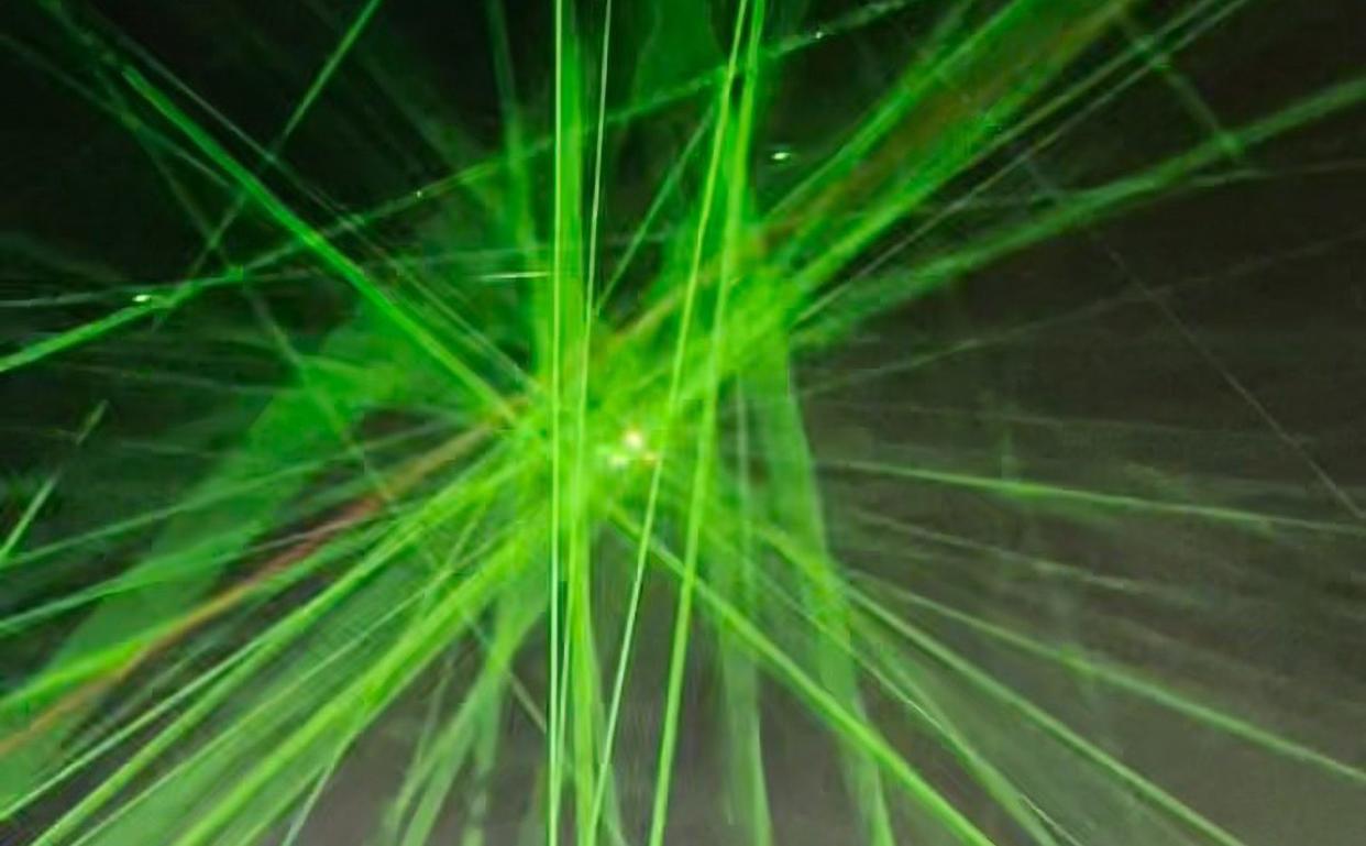 People at the festival point their lasers at the aircraft