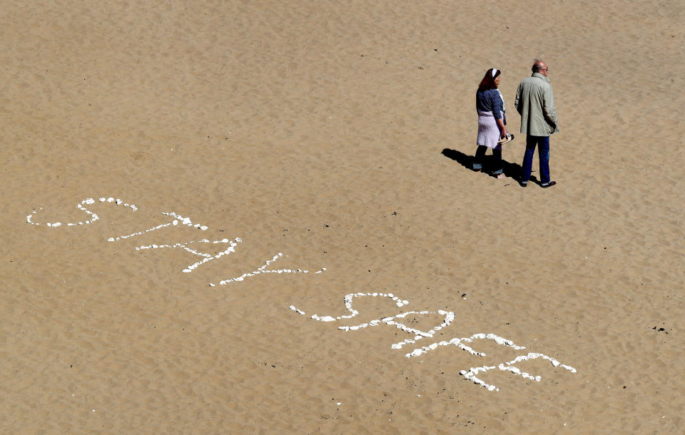 A couple view the empty beach in Broadstairs, Kent, as the UK continues in lockdown to help curb the spread of the coronavirus.