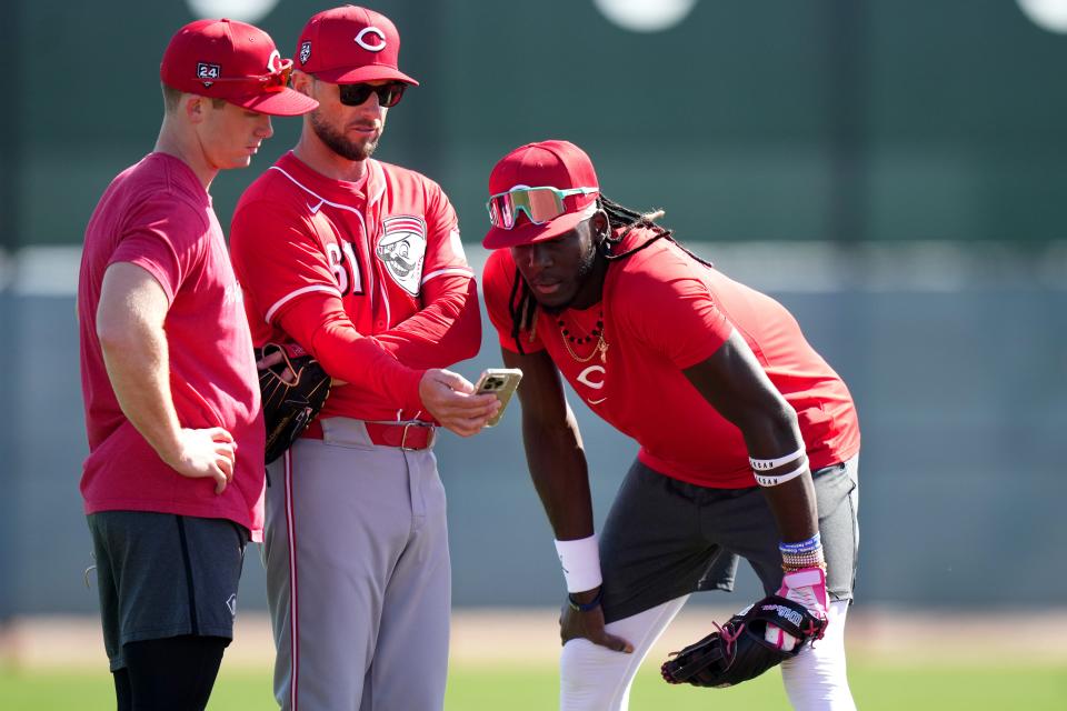 Cincinnati Reds shortstop Matt McLain (9), bench coach Jeff Pickler and shortstop Elly De La Cruz (44) review notes during spring training workouts, Wednesday, Feb. 14, 2024, at the team’s spring training facility in Goodyear, Ariz.
