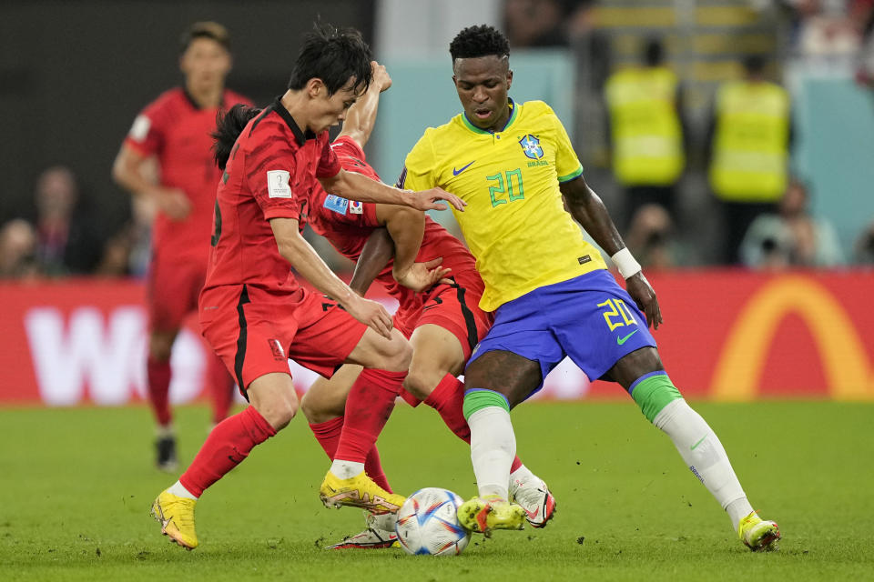 Brazil's Vinicius Junior, right, fights for the ball with South Korea's Kim Moon-hwan, left, and Paik Seung-ho during the World Cup round of 16 soccer match between Brazil and South Korea, at the Stadium 974 in Doha, Qatar, Monday, Dec. 5, 2022. (AP Photo/Martin Meissner)
