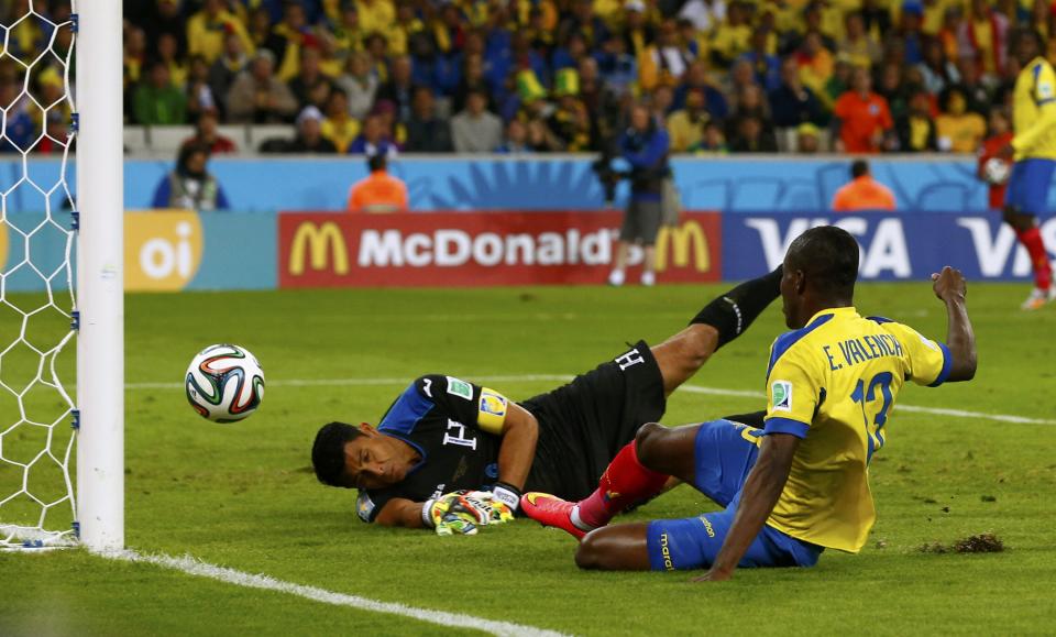 Ecuador's Enner Valencia scores past goalkeeper Noel Valladares of Honduras during their 2014 World Cup Group E soccer match at the Baixada arena in Curitiba June 20, 2014. REUTERS/Darren Staples (BRAZIL - Tags: TPX IMAGES OF THE DAY SOCCER SPORT WORLD CUP)