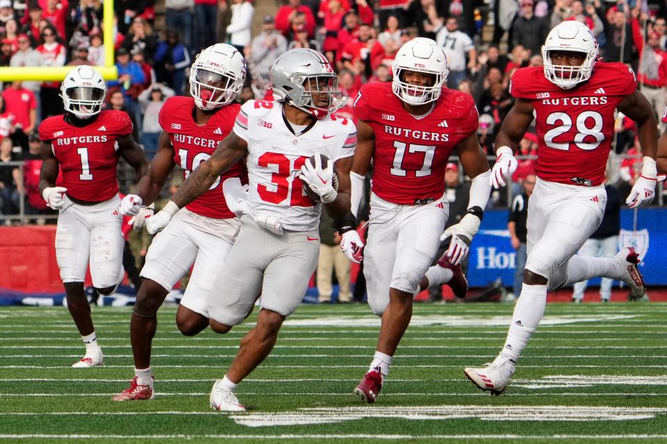 Nov 4, 2023; Piscataway, New Jersey, USA; Ohio State Buckeyes running back TreVeyon Henderson (32) runs past the Rutgers Scarlet Knights defense for 65 yards after making a catch during the second half of the NCAA football game at SHI Stadium. Ohio State won 35-16.