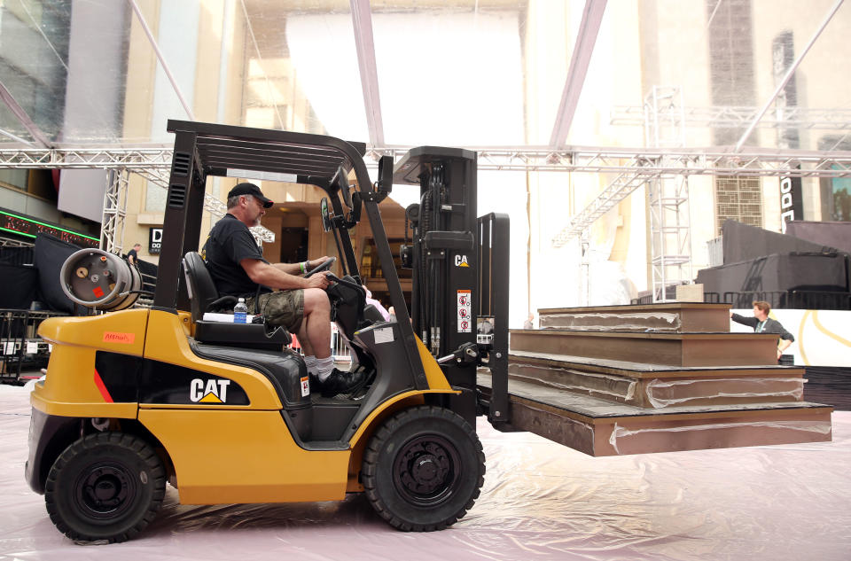 A worker drives a forklift down the red carpet as preparations are made for the 86th Academy Awards in Los Angeles, Wednesday, Feb. 26, 2014. The Academy Awards will be held at the Dolby Theatre on Sunday, March 2. (Photo by Matt Sayles/Invision/AP)