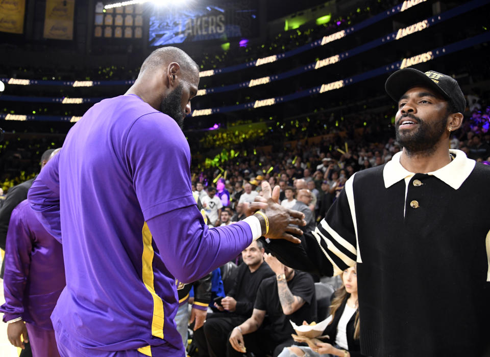 Dallas Mavericks point guard Kyrie Irving greets Los Angeles Lakers star LeBron James at his former teammate's first-round playoff Game 6 against the Memphis Grizzlies in April. (Kevork Djansezian/Getty Images)