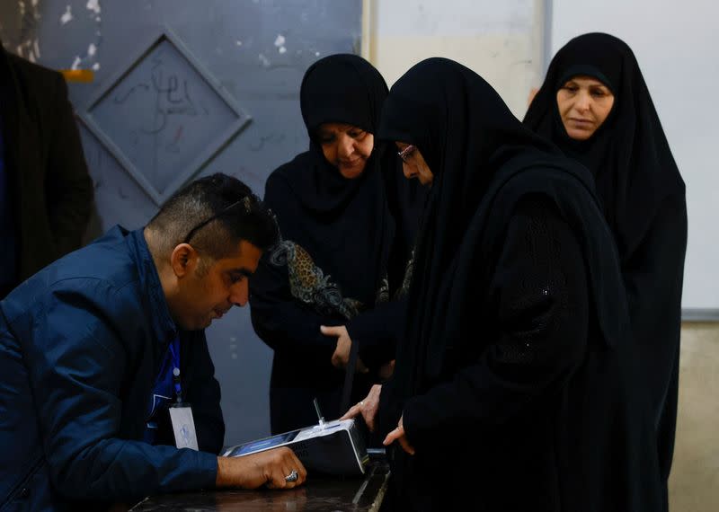 An Iraqi woman has her fingerprints scanned to verify her identity before voting at a polling station, during Iraq's provincial council elections, in Baghdad