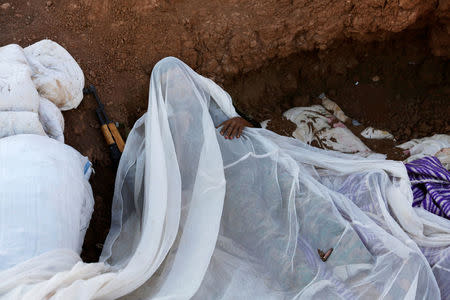 A rebel fighter from 'Jaysh al-Sunna' sleeps in a trench in the southern Aleppo countryside, Syria June 10, 2016. REUTERS/Khalil Ashawi