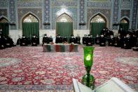 Servants of the holy shrine of Imam Reza sit near the coffin of Iranian nuclear scientist Mohsen Fakhrizadeh, in Mashhad