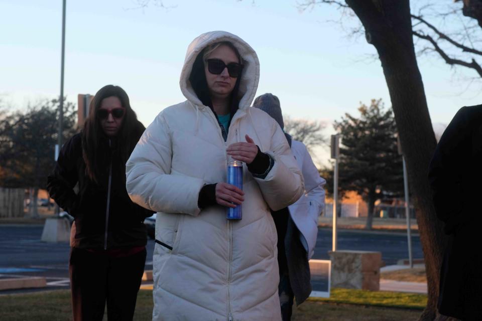 Halei Skinner fights to keep her candle lit amongst the Panhandle winds Thursday at the Lights to End Human Trafficking Event in Amarillo.