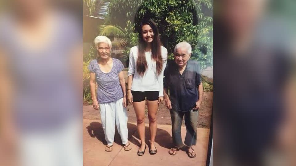 CNN Business Writer Catherine Thorbecke (center) with her late grandparents in Lahaina, Hawaii, circa 2013. Her grandparents passed away before the 2023 fires, but the home they lived in and gardens they planted are destroyed. - Catherine Thorbecke/CNN