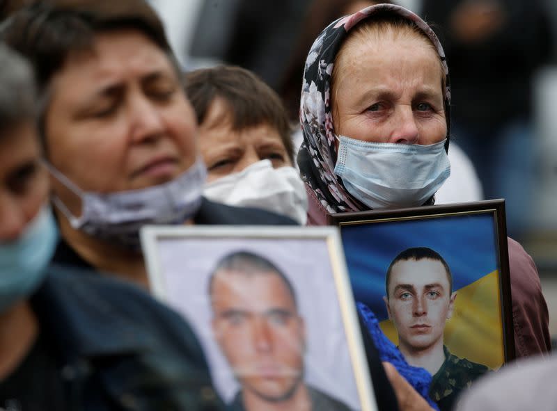 FILE PHOTO: Relatives hold portraits of servicemen, killed in conflict in eastern Ukraine, during a rally in Kyiv