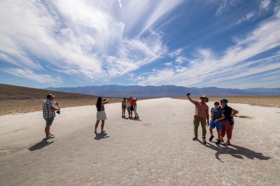 People walk on the salt flat at Badwater, the lowest point in North America at 282 feet below sea level, as the temperature rises well into the upper 120s at Death Valley National Park on July 16, 2023 near Furnace Creek, California.