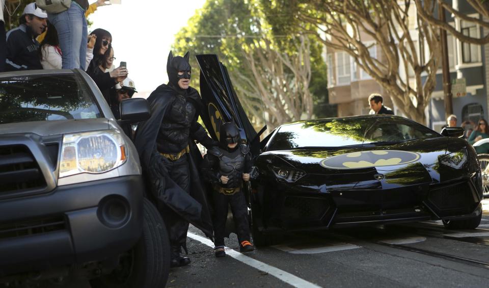 Leukemia survivor Miles dressed as "Batkid" arrives with a man dressed as Batman to rescue a woman in distress as part of a day arranged by the Make-A-Wish Foundation in San Francisco, California