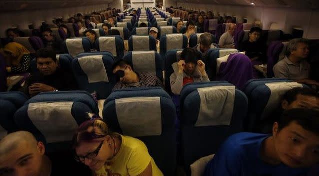 Passengers remain in their seats onboard Malaysia Airlines Boeing 777-200ER flight MH318 as it cruises towards Beijing over the South China Sea. Photo: Reuters