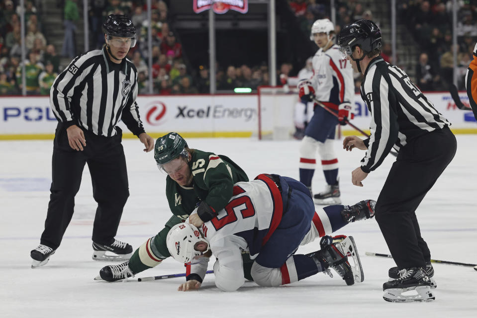Minnesota Wild center Mason Shaw (15) fights with Washington Capitals defenseman Matt Irwin at the end of the second period of an NHL hockey game, Sunday, March 19, 2023, in St. Paul, Minn. (AP Photo/Stacy Bengs)