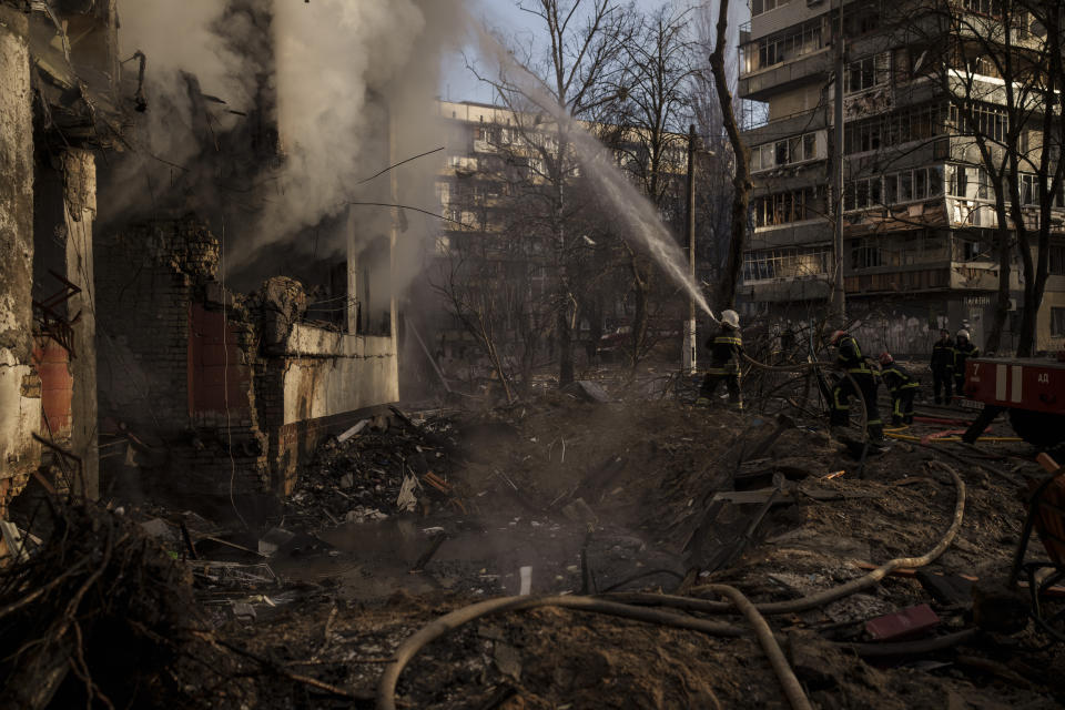 Ukrainian firefighters work in an apartment building after bombing in Kyiv, Ukraine, Tuesday, March 15, 2022. (AP Photo/Felipe Dana)