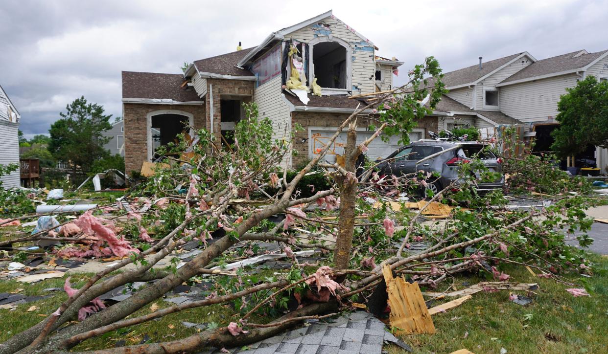 Debris from damaged homes litters Nutmeg Lane in Naperville, Ill., Monday, June 21, 2021, following an overnight tornado. 