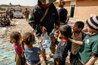 <p>An special forces soldier gives bottles of water to displaced children as Iraqi forces battle with Islamic State militants, in western Mosul, Iraq, Feb. 28, 2017. (Zohra Bensemra/Reuters) </p>