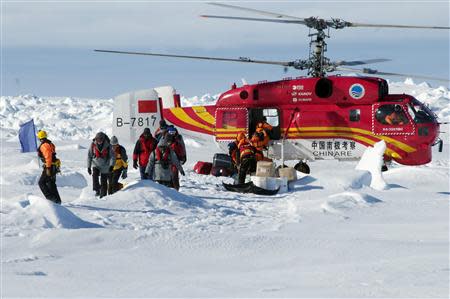 A helicopter from the Xue Long (Snow Dragon) Chinese icebreaker unloads rescued passengers from the ice-bound Russian ship, Akademik Shokalskiy, in East Antarctica, some 100 nautical miles (185 km) east of French Antarctic station Dumont D'Urville and about 1,500 nautical miles (2,800 km) south of Hobart, Tasmania, January 2, 2014, in this handout courtesy of Fairfax's Australian Antarctic Division. REUTERS/Fairfax/Australian Antarctic Division/Handout via Reuters