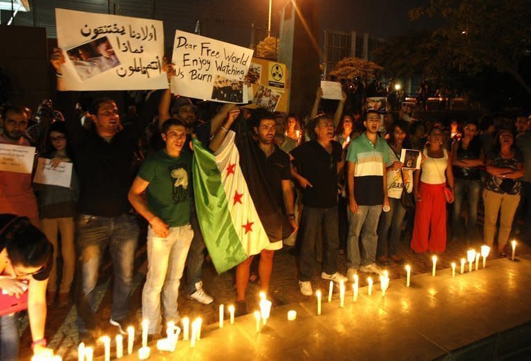 Lebanese and Syrian civilians hold a candlelit vigil in front of the UN headquarters in Beirut, in solidarity with Syrian civilians killed in attacks in the suburbs of Damascus on August 21, 2013. The regime in war-torn Syria came under intense pressure Thursday to allow UN inspectors to probe an alleged chemical weapons attack near Damascus which the opposition says killed hundreds