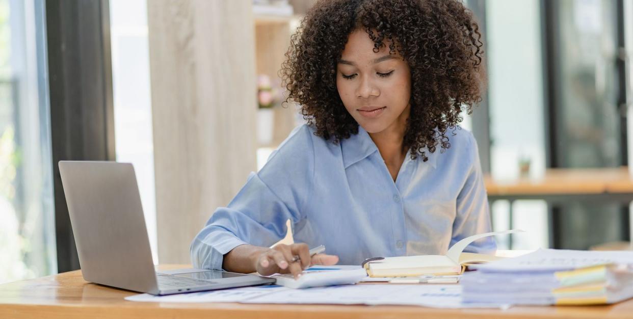 woman works on laptop as she calculates finances