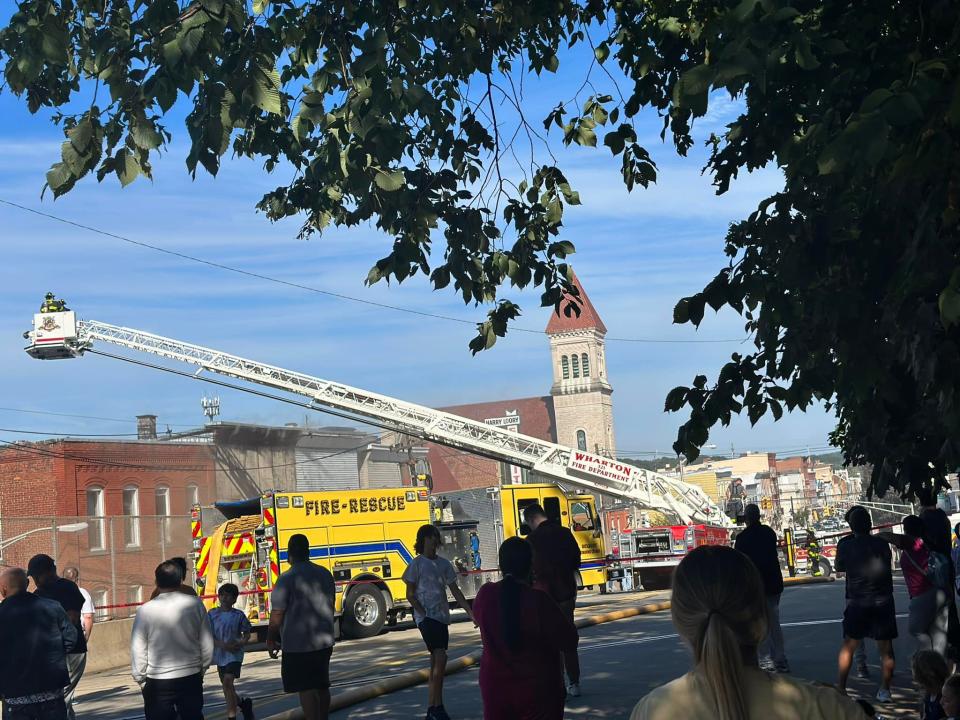 A Wharton Fire Department truck hoists a firefighter above an Sept. 16 fire near the corner of Dewey and Whitewell Street in Dover.