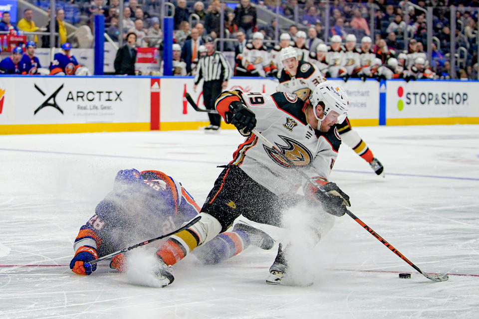 Anaheim Ducks left wing Max Jones (49) evades the challenge of New York Islanders defenseman Alexander Romanov during the third period of an NHL hockey game in Elmont, N.Y., Wednesday, Dec. 13, 2023. The Islanders won 4-3. (AP Photo/Peter K. Afriyie)