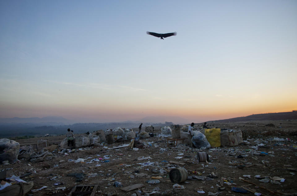 In this May 29, 2012 photo, a vulture flies over Jardim Gramacho, one of the world's largest open-air landfills, in Rio de Janeiro, Brazil. Jardim Gramacho, a vast, seaside mountain of trash where thousands of people made a living sorting through the debris by hand, is closing after three decades in service. (AP Photo/Victor R. Caivano)