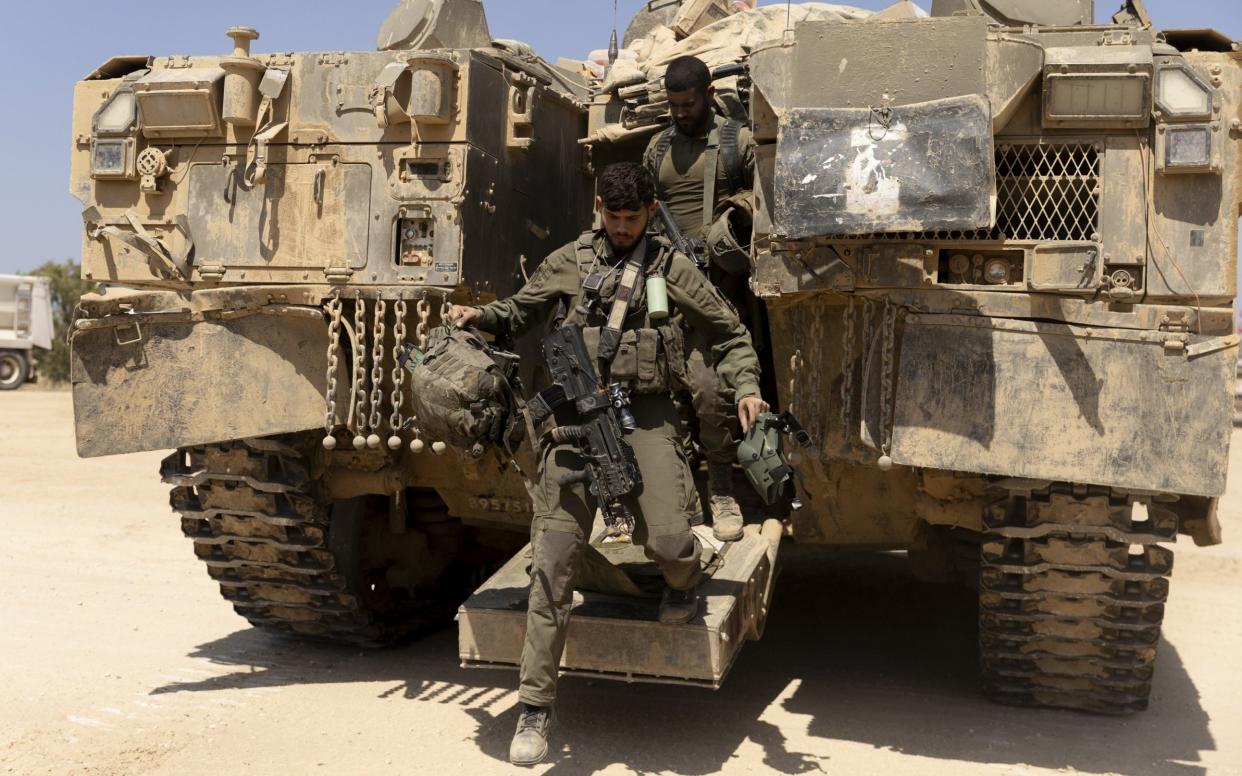 Israeli soldiers exit an armored personnel carrier near the border with the Gaza