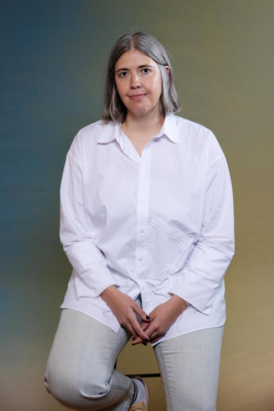 Chelsea McMullan smiles while wearing a white blouse and light colored pants.