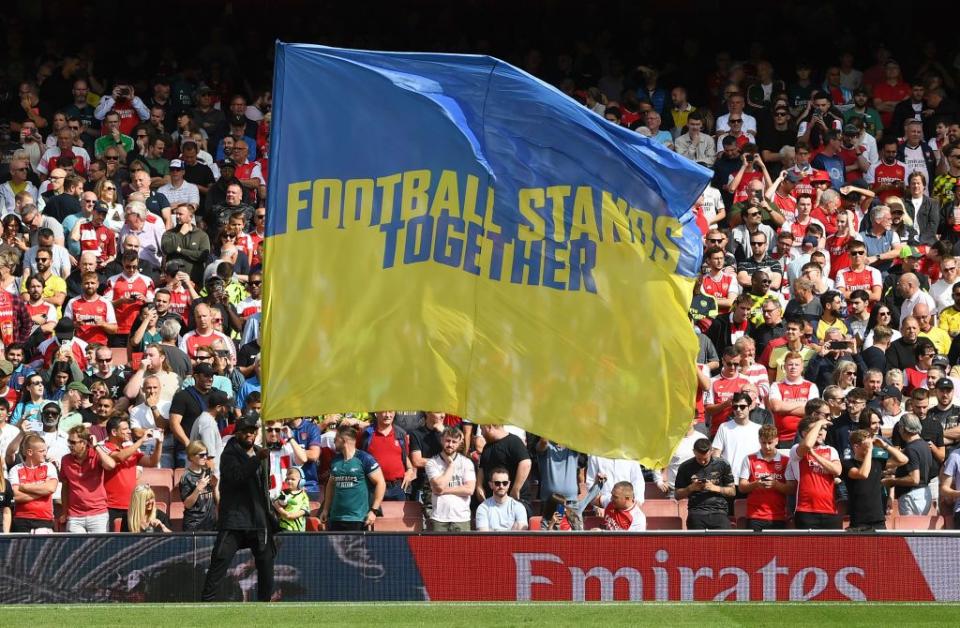 "Football stands together" is written on a Ukrainian flag seenat the Premier League match between Arsenal FC and Fulham FC at Emirates Stadium on Aug. 26, 2023 in London, England. (Stuart MacFarlane/Arsenal FC via Getty Images)