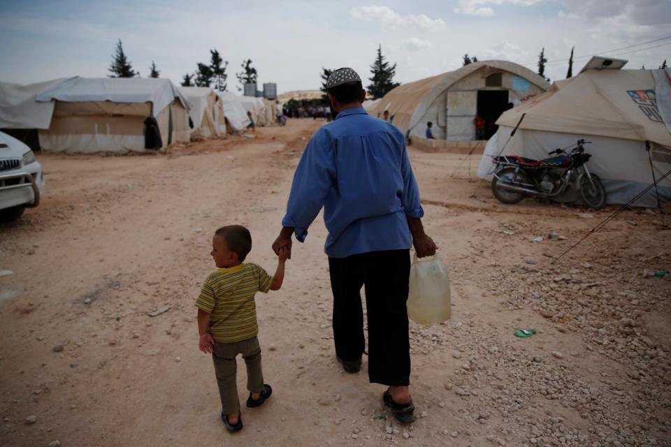 Syrer gehen in einem Lager für Binnenvertriebene in al-Bab, Nordsyrien (AP)