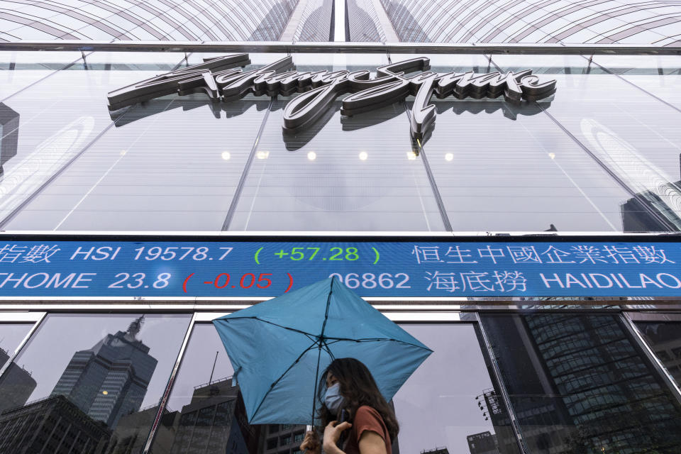 A pedestrian passes by the Hong Kong Stock Exchange electronic screen in Hong Kong, Wednesday, June 14, 2023. Asian stock markets followed Wall Street higher on Wednesday after a cooler reading on U.S. inflation fueled hopes the Federal Reserve will postpone a possible interest rate hike. (AP Photo/Louise Delmotte)