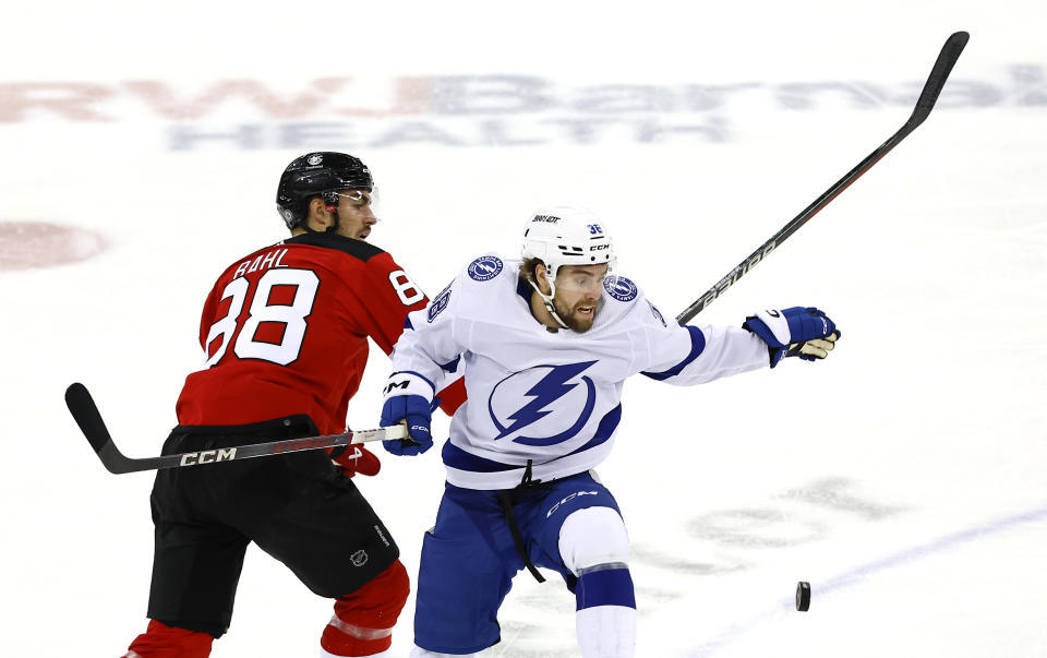 Tampa Bay Lightning left wing Brandon Hagel (38) battles New Jersey Devils defenseman Kevin Bahl (88) for the puck during the third period of an NHL hockey game, Sunday, Feb. 25, 2024, in Newark, N.J. The Tampa Bay Lightning won 4-1. (AP Photo/Noah K. Murray)