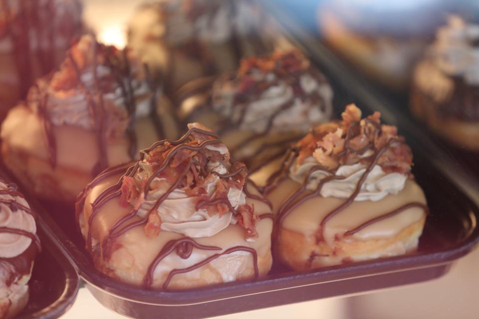 A tray of fresh maple bacon doughnuts are on display at Donuts Delite West in Rochester on March, 14, 2022.