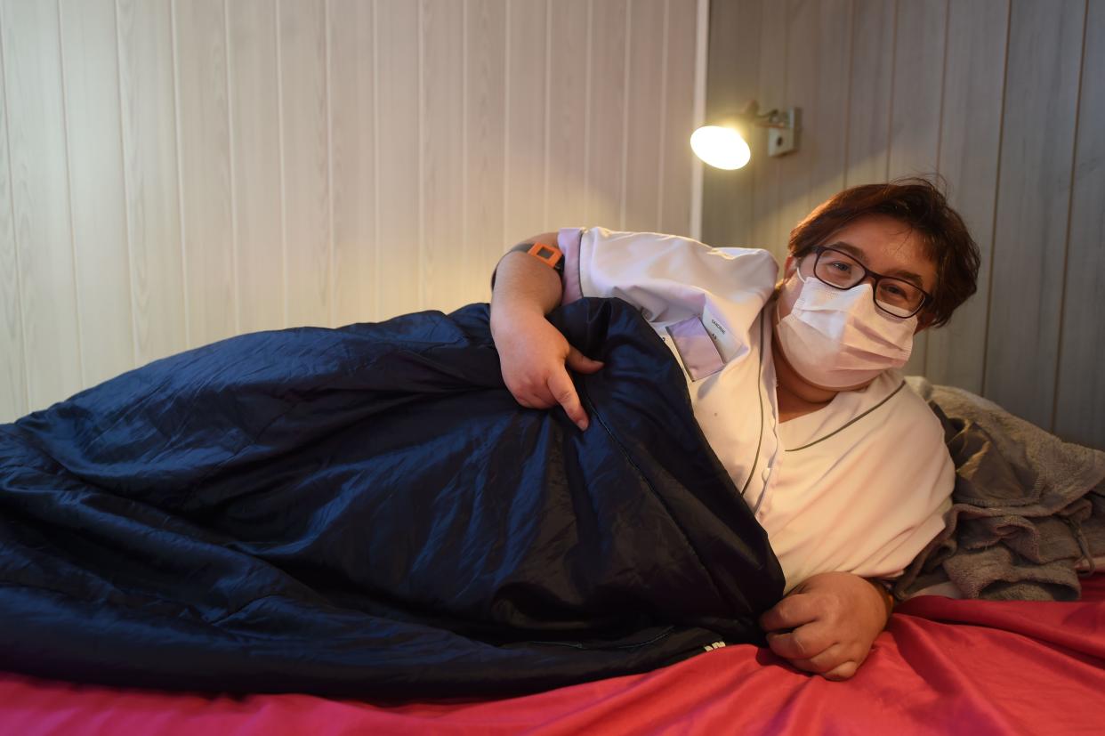 Sandrine Lalouze, 42 years old caregiver, mother of two daughters aged 12 and 16, smiles behind her protective mask as she poses in a bedroom of a dorm-truck, normally used to host participants of Le Mans Classic race, installed in front of the retirement home, in Bouere, western France, on April 14, 2020, on the 29th day of a strict lockdown aimed at curbing the spread of the COVID-19 pandemic, caused by the novel coronavirus. - The staff sleep in the dorm-truck next to the retirement home in order to protect the 60 residents from possible contamination while protecting their families. (Photo by JEAN-FRANCOIS MONIER / AFP) (Photo by JEAN-FRANCOIS MONIER/AFP via Getty Images)