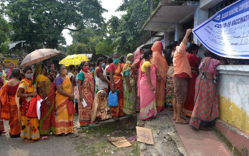 People queue to receive a dose of the Covishield vaccine at a primary school in Siliguri, India on 3 August 2021 - Diptendu Dutta/AFP