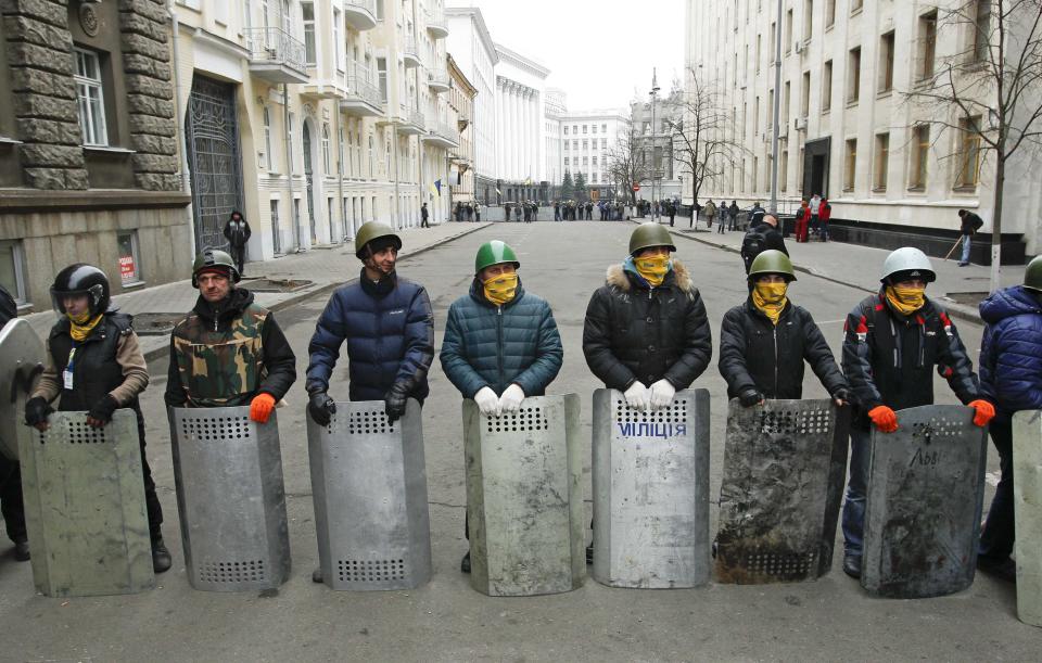 Anti-government protesters guard a street leading to the presidential administration building in Kiev