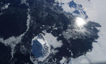 <p>Sea ice floats near an island as seen from NASA’s Operation IceBridge research aircraft in the Antarctic Peninsula region, on Nov. 3, 2017, above Antarctica. (Photo: Mario Tama/Getty Images) </p>