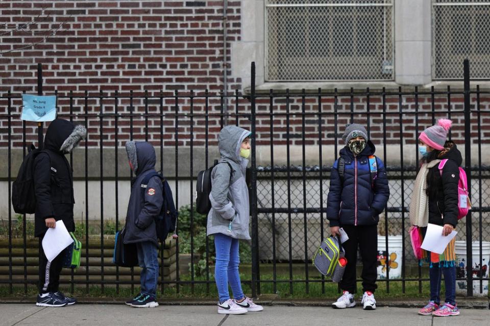 Children returning to school line up Monday before entering P.S. 179 Kensington in New York City. The New York City public school system has reopened for in-person learning after a pre-Thanksgiving shutdown due to rising COVID-19 cases in the city.