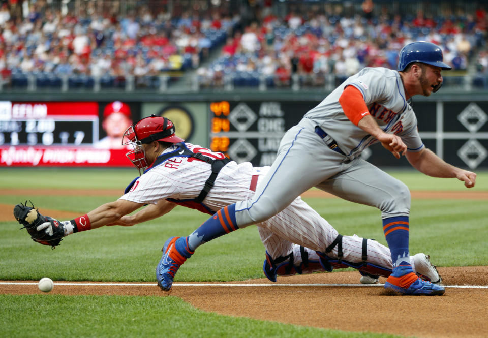 New York Mets' Pete Alonso, right, scores past Philadelphia Phillies catcher J.T. Realmuto on a double by Michael Conforto during the first inning of a baseball game, Monday, June 24, 2019, in Philadelphia. (AP Photo/Matt Slocum)