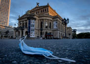 FILE - In this file photo dated Saturday, Oct. 31, 2020, a face mask discarded in front of the Old Opera in Frankfurt, Germany. With accusations of being slow off the blocks in the race to immunise its citizens against COVID-19, Germany faces the problem of having a glut of vaccines and not enough arms to inject. With its national vaccine campaign lagging far behind that of Israel, Britain and the United States, there are growing calls in this country of 83 million to ditch or rewrite the rulebook. (AP Photo/Michael Probst, FILE)