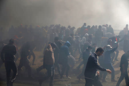 Palestinian demonstrators are seen during clashes with Israeli troops at a protest demanding the right to return to their homeland, at the Israel-Gaza border, east of Gaza City, April 13, 2018. REUTERS/Mohammed Salem