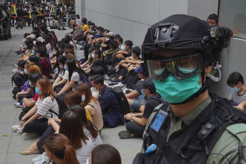 2020年5月27日，香港的反政府示威者在銅鑼灣被警察逮捕後坐在地上。（美聯社）